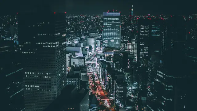 Aerial view of city towers and glowing streets at night
