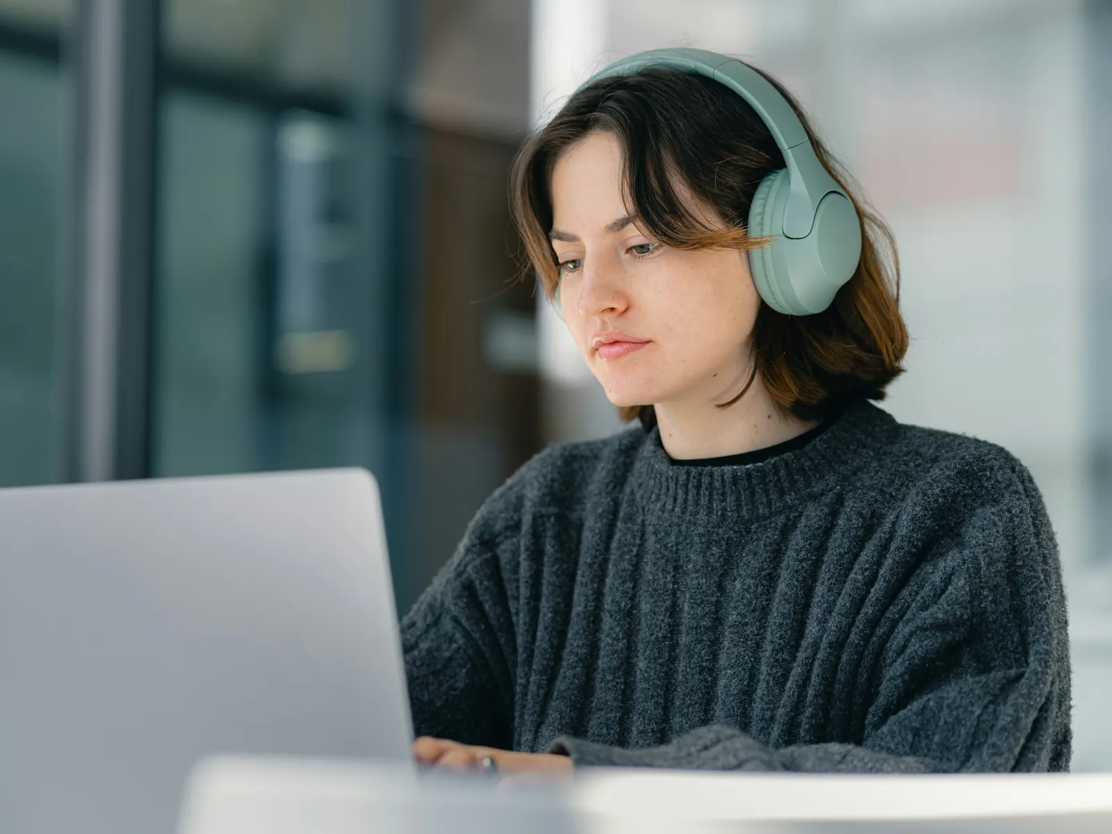 Student wearing headphones following an online course on a laptop