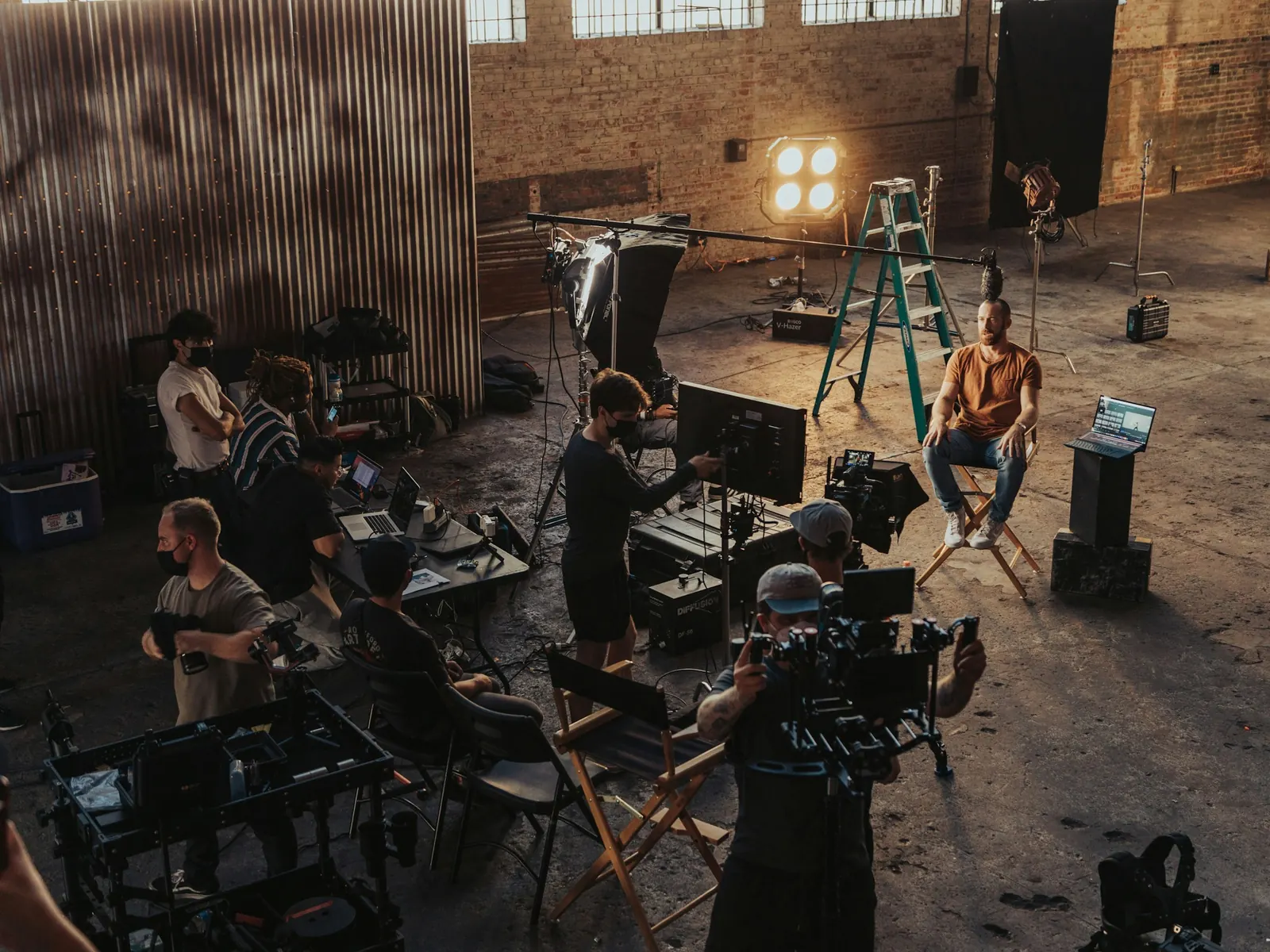 Film crew setting up cameras and lights on a warehouse film set